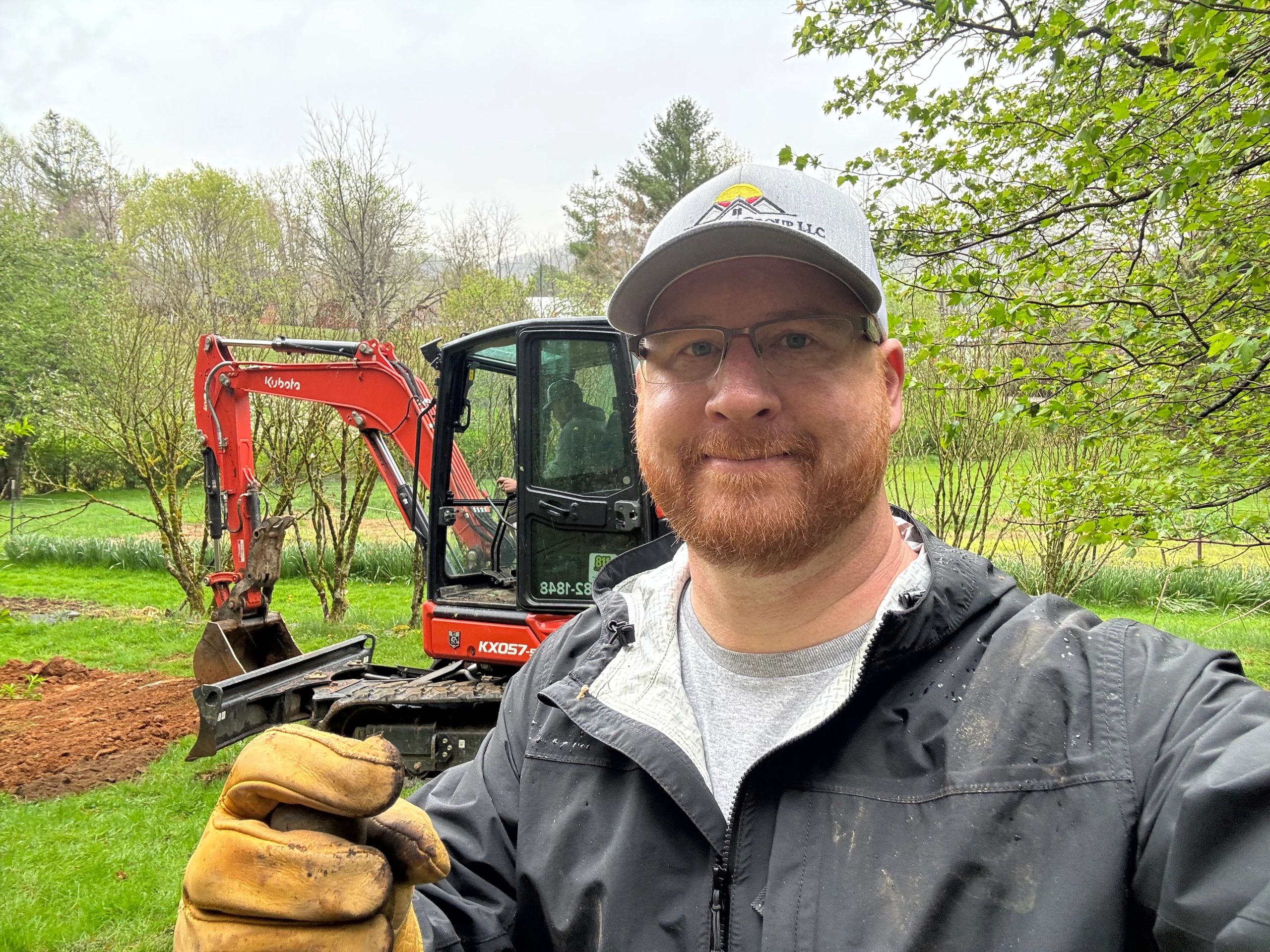 Riverfront Group owner Adam Grabousky in front of a red Kubota mini-excavator