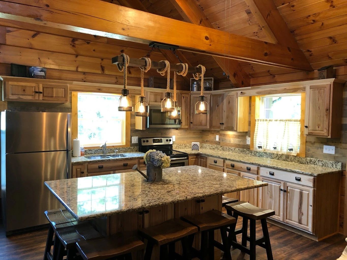 Rustic log cabin kitchen remodel with wood beams and granite island
