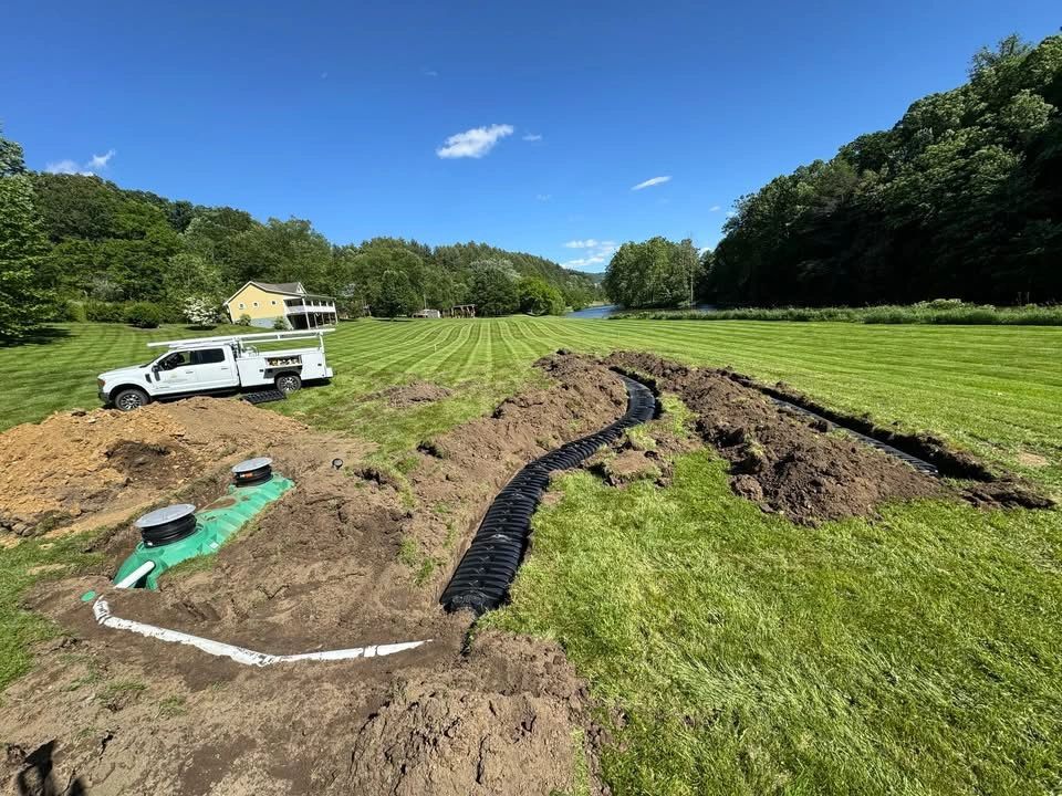 Aerial view of completed septic drainfield installation, green valley and mountains